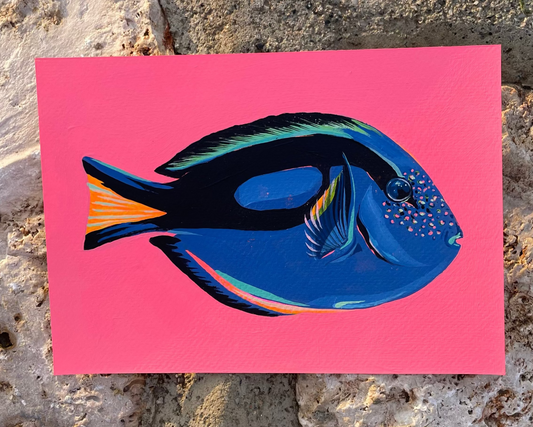 Colorful fish painting of a blue tang on a pink background, photographed on a stone background